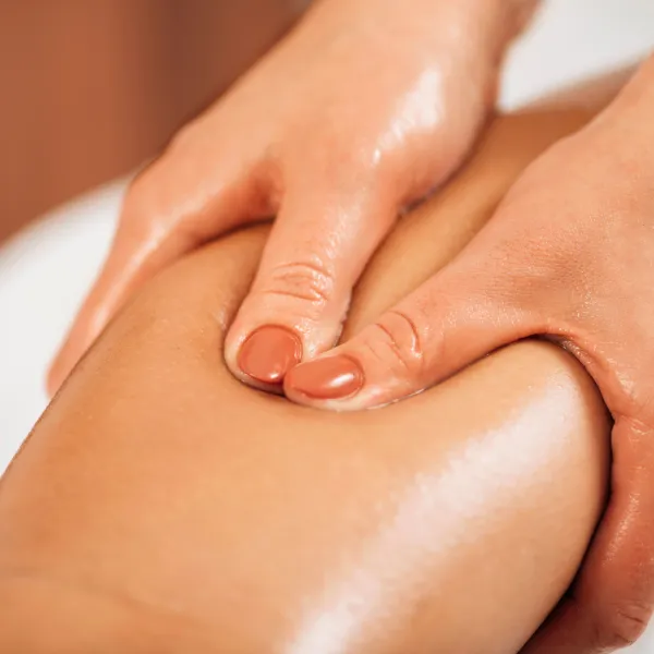 Une personne recevant un massage sur sa jambe pour le drainage lymphatique.